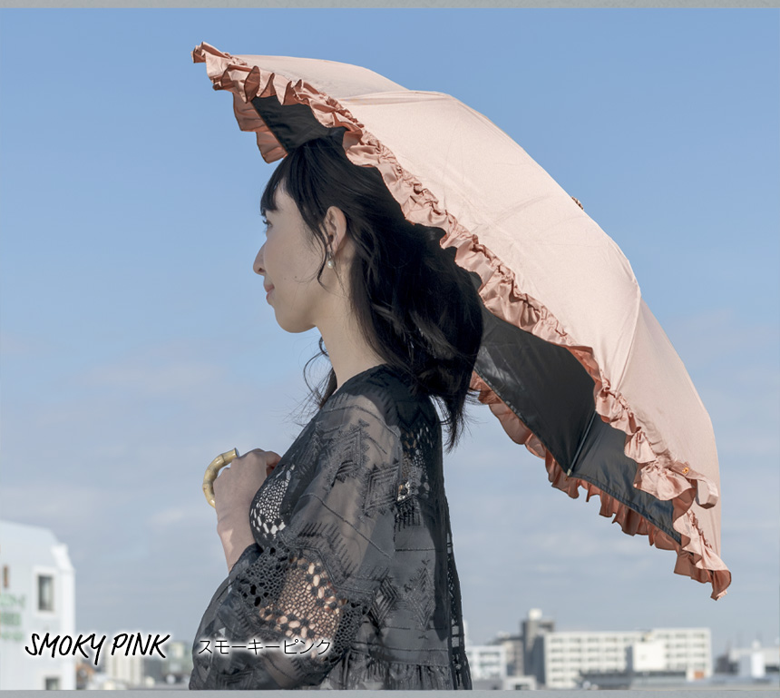 スモーキーピンクのフリル日傘をさす女性